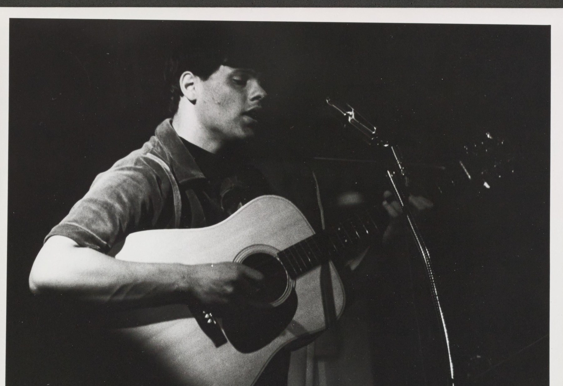 Dev Singh singing at a microphone with an acoustic guitar, Bear's Lair cabaret, Berkeley Folk Music Festival, 1 July 1966